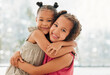 © Kay Abrahams/peopleimages.com - Cute, adorable and sweet girls hugging and bond with a happy and healthy childhood growing at home. Portrait of innocent and loving sisters with a bright smile, affection and relaxing in the house
