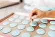 The process of making macaroons. Cookie baking. A woman prepares macaroons for baking. Blue macaroons