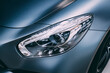 Close-up detailed view of the headlights of a luxury car in the garage. Halogen and xenon headlamp lighting and auto tuning systems