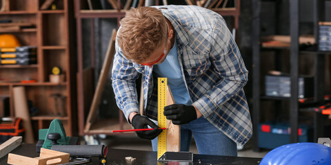 Wall Mural - Male carpenter with ruler and pencil in workshop