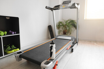 Poster - Modern treadmill with bottle of water in gym