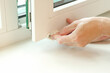 © Анастасія Шатирова - Close-up of male hands installing roller blinds on the window. Installation of roller blinds