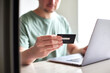 © Maria Fuchs - CloseUp von Mann mit Kreditkarte in der Hand benutzt Laptop: Online Shopping, Rechnung bezahlen, Urlaub buchen, Geld Ausgeben, Internet Banking