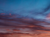 Fototapeta Fototapeta z niebem - Wieczorne, lekko zachmurzone niebo. Chmury światłem zachodzącego słońca zabarwione są na czerwono. Miejscami widać niebieskie niebo.