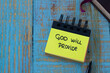 God will provide, a handwritten text note in a small notebook with a closed Holy Bible Book on a rustic wooden background. Top table view. Christian biblical concept.