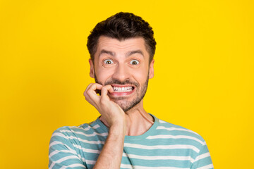 Poster - Closeup photo of young handsome funny guy bite finger nervous about driving test isolated on yellow color background