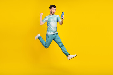 Canvas Print - Full size body photo of young funny guy jump air run take his prize bet online money phone isolated on yellow color background