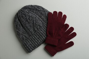 Poster - Woolen gloves and hat on light grey background, flat lay