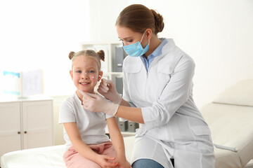 Poster - Doctor applying cream onto skin of little girl with chickenpox in clinic. Varicella zoster virus