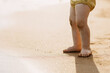 © Bostan Natalia - Closeup of little child feet standing on the beach.