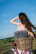 brunette woman with long hair and lavender flowers in blurred wicker basket.