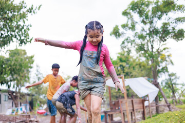 Wall Mural - Asian girl climb on wooden railing. Diverse happiness kid group playing in playground at summer camp learning