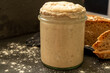 Homemade sourdough starter in glass on dark background and graham bread