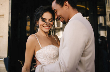 Stylish stunning couple together on their wedding day against the backdrop of a city hotel. Luxury wedding of a beautiful couple