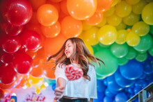 Happy Woman Standing Against Balloons