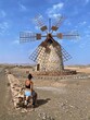 Young woman observing an old windmill.