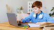 © Stavros - Teenager boy doing homework online at home. He closely follows the teacher's story online. Format photo 16x9.