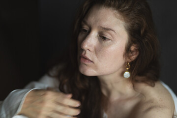 Studio portrait of a young woman against a dark background