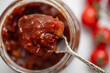 Homemade spicy tomato chutney on a spoon from a jar.