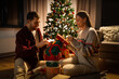 © Syda Productions - holidays, celebration and people concept - happy couple opening christmas gifts at home