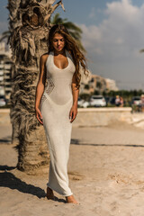 Wall Mural - Sexy fashion model posing in white dress on the beach.