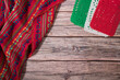 Mexican handmade tablecloth on  vintage wooden table with tricolor decorations