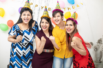 Cheerful young Indian girls making party and celebrating birthday together.