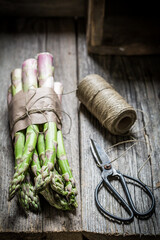 Wall Mural - Fresh green asparagus wrapped in string on table