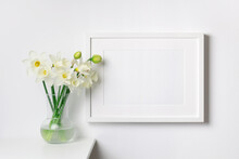 Landscape Frame Mockup On White Wall With Spring Daffodils Flowers Bouquet