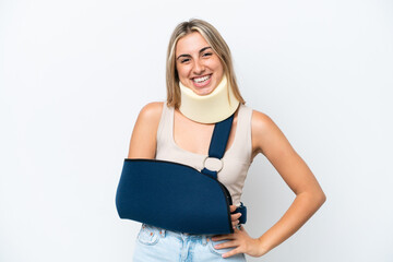 Wall Mural - Woman with broken arm and wearing a sling isolated on white background posing with arms at hip and smiling