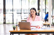 © David - Young Business Asian woman talking on a smartphone and working in an office. Asian female Business finance sitting at his workplace.