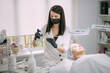 © Anna - Cosmetologist and dermatologist cleans the face of a lying woman patient in a beauty salon. Young woman on a cosmetology procedure for facial skin care