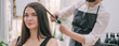 © Anna - Professional hairdresser woman in an apron makes a haircut to a young girl in a beauty salon.