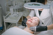 © Anna - Cosmetologist and dermatologist cleans the face of a lying woman patient in a beauty salon. Young woman on a cosmetology procedure for facial skin care