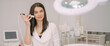 © Anna - Portrait of a young beautiful woman beautician in a medical white uniform in her office with cosmetology equipment