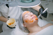 © Anna - Cosmetologist and dermatologist makes a moisturizing, rejuvenating woman lying patient in a beauty salon.