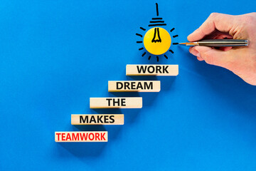 Wall Mural - Teamwork makes dream work symbol. Concept words Teamwork makes the dream work on wooden blocks on a beautiful blue background. Businessman hand. Business Teamwork makes dream work concept. Copy space.