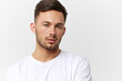 © SHOTPRIME STUDIO - Sad frustrated unhappy tanned handsome man in basic t-shirt tired of problems look at camera posing isolated on white studio background. Copy space Banner Mockup. People emotions Lifestyle concept