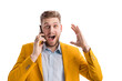 © MYDAYcontent - Positive man expressing surprise while making phone call in bright studio. Excited young male raising hand with happy smile. Modern technology concept.