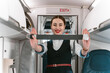Beautiful flight attendant demonstrates flight safety instruction by using seat belt 