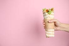 Woman Holding Delicious Chicken Shawarma On Pink Background, Closeup. Space For Text