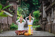 © Odua Images - balinese couple do the prayer to god in the morning. hindu people make an offering to their god using canang