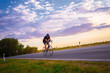 © Solid photos - Young biker cycling with bicycle on the road in summer