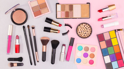 MAke up and cosmetics products pattern on grey and pastel pink background. Flat lay