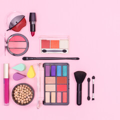 Wall Mural - Colorful make up products layout on pastel pink background. Flat lay