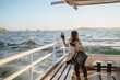 woman sitting on a ferry boat crossing the bosphorus and taking photo using her phone