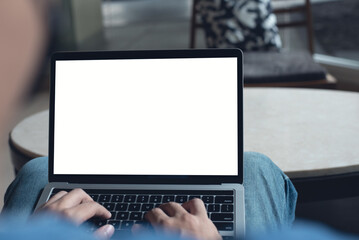 Canvas Print - Mockup image of laptop computer. Casual business man, freelancer using and typing on laptop computer with blank white screen at coffee cup, over shoulder view