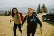 © BGStock72 - Smiling couple walking with backpacks over green hills
