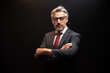 © Jirus - Portrait of senior Businessman standing in elegant black suit and red tie with arms crossed. isolated on black background.