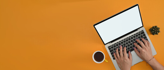 Poster - Above view of male designer's hands painted nails using a empty screen of laptop computer on the yellow background.